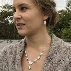 Necklace with silver magnolia flower and 7 white buffalo turquoise stones on woman. Bridal necklace